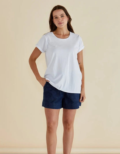 Woman wearing a white t-shirt and blue shorts on a beige background