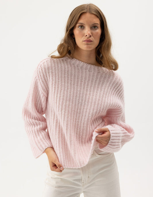 woman wearing pale pink ribbed knitted sweater
