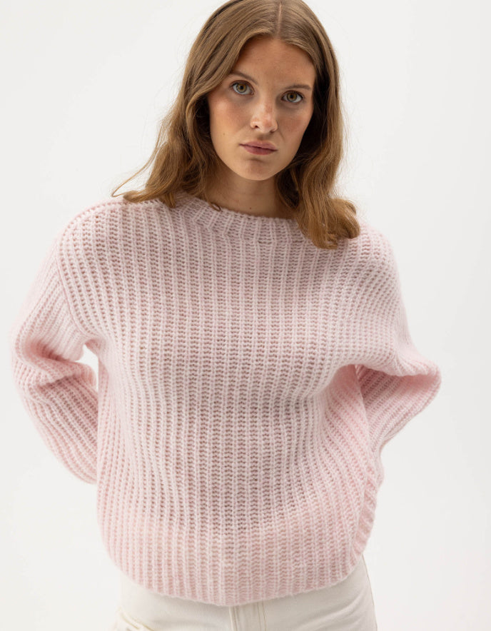 woman wearing pale pink ribbed knitted sweater