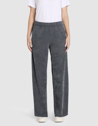Person wearing grey wide leg corduroy pants on a white background