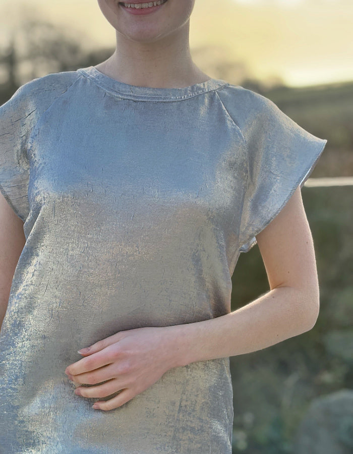 champagne coloured top with crew neck and fluted sleeves