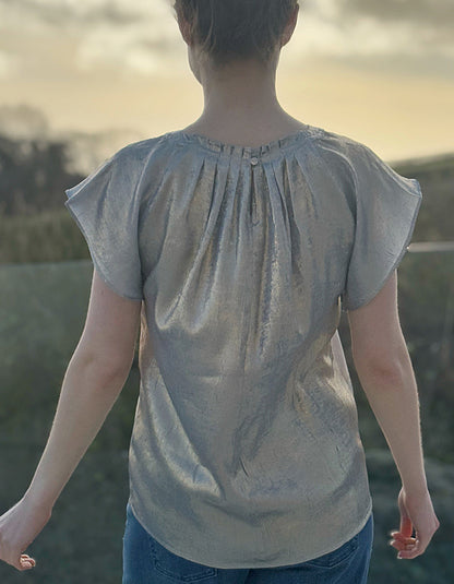 champagne coloured top with crew neck and fluted sleeves