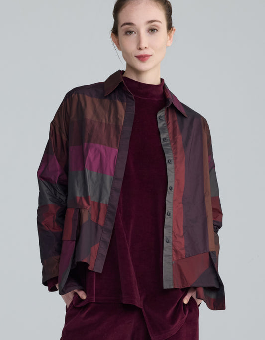 Person wearing a burgundy check taffeta patterned shirt over a matching outfit on a plain background