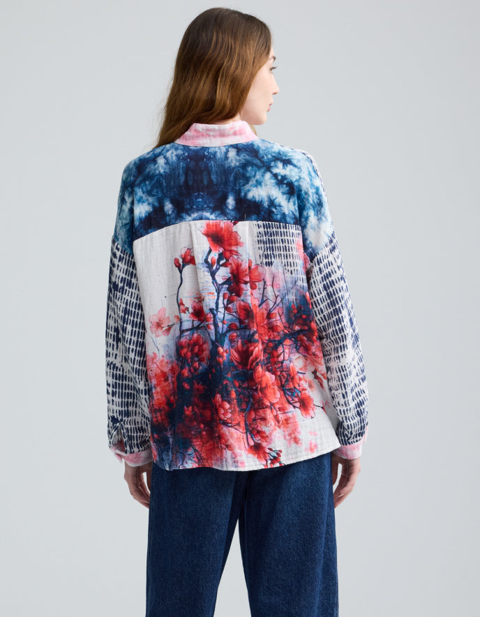 Woman wearing a colorful blouse with abstract patterns on a gray background