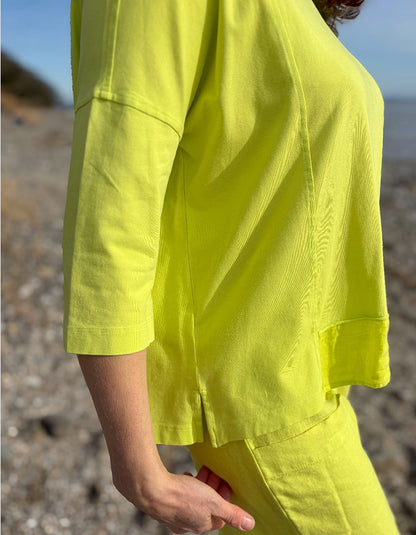 Person wearing a bright yellow outfit on a beach