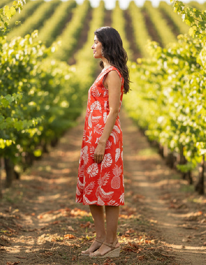 Woman in a red dress standing in a vineyard