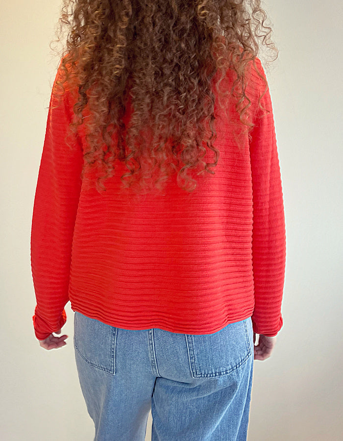 short wide boxy cardigan with ribbed texture, long sleeves and scoop neck in coral