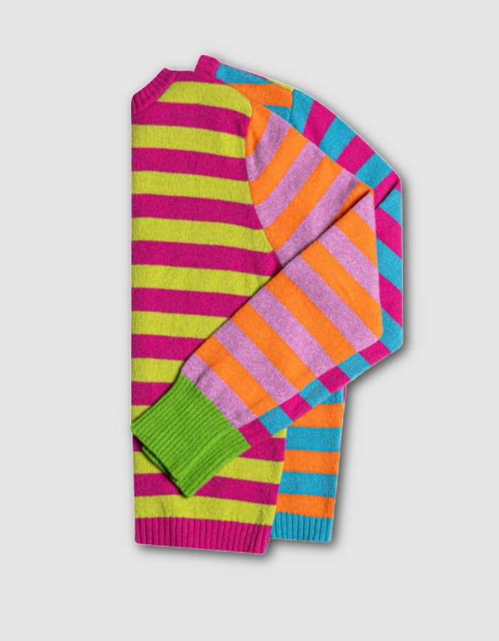 A folded knit sweater with bold horizontal stripes in neon pink, lime green, orange, purple, and turquoise on a light gray background.