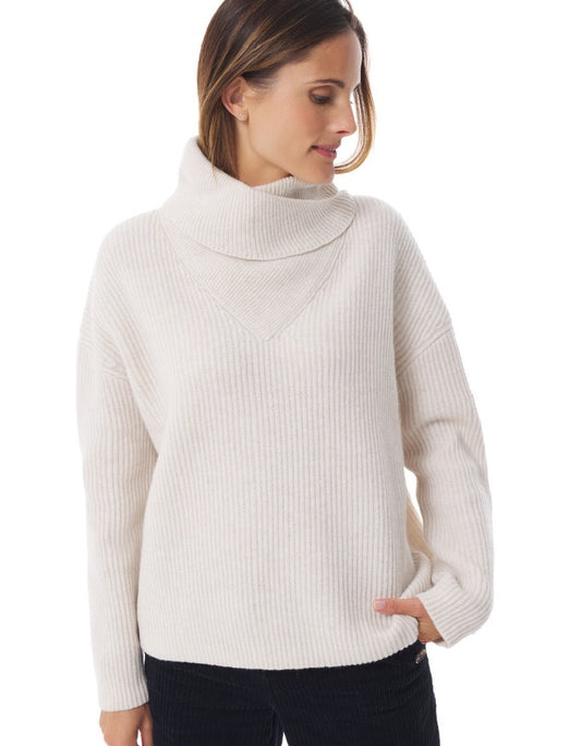 Woman wearing a beige ribbed sweater on a white background