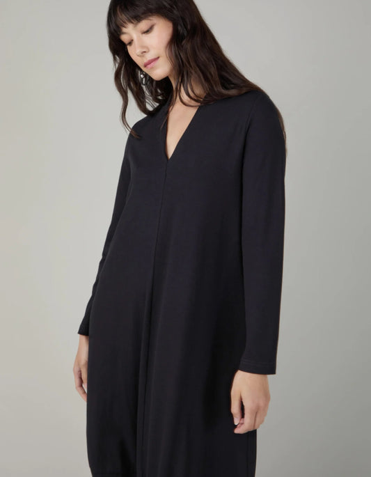 Woman wearing a black dress against a neutral background