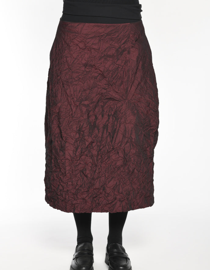 Maroon textured skirt worn by a person on a white background