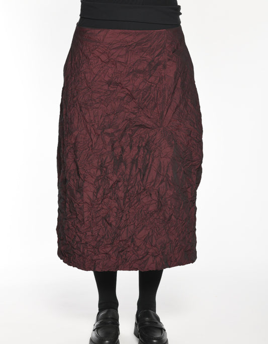 Maroon textured skirt worn by a person on a white background