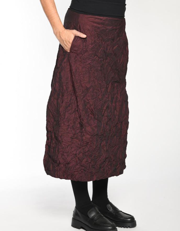 Maroon textured skirt worn by a person on a white background