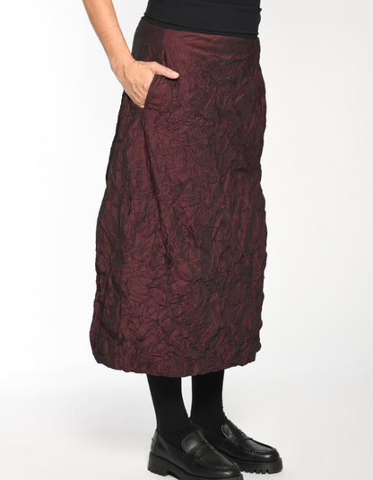 Maroon textured skirt worn by a person on a white background