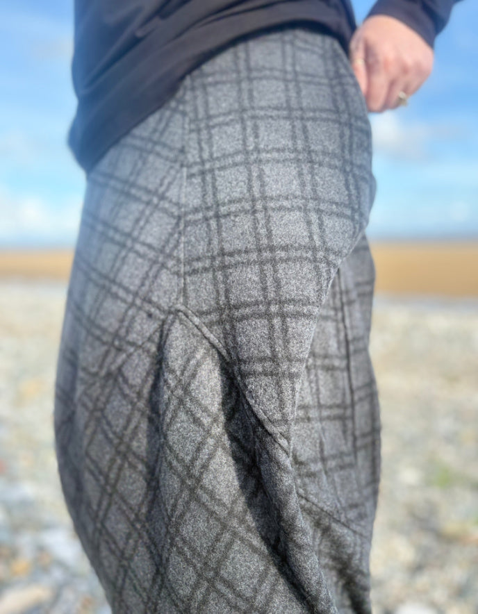 Person wearing grey checkered skirt  on a beach