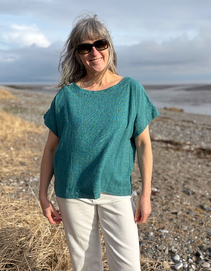 woman wearing boxy teal linen top with jeans