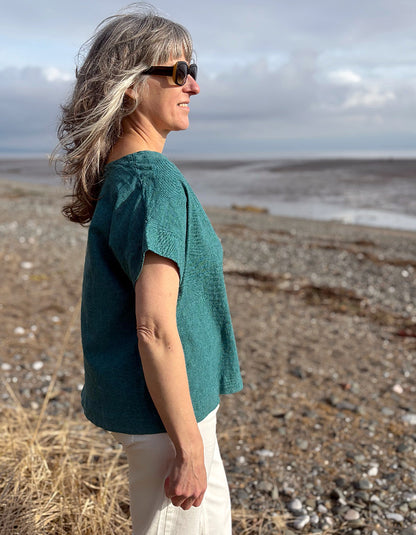 woman wearing boxy teal linen top with jeans