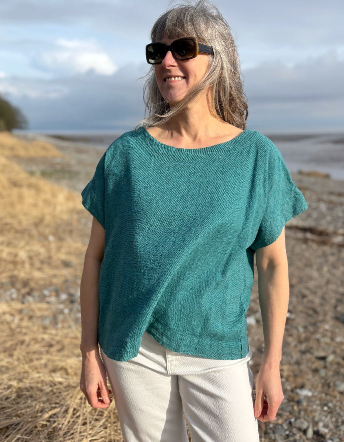 woman wearing boxy teal linen top with jeans