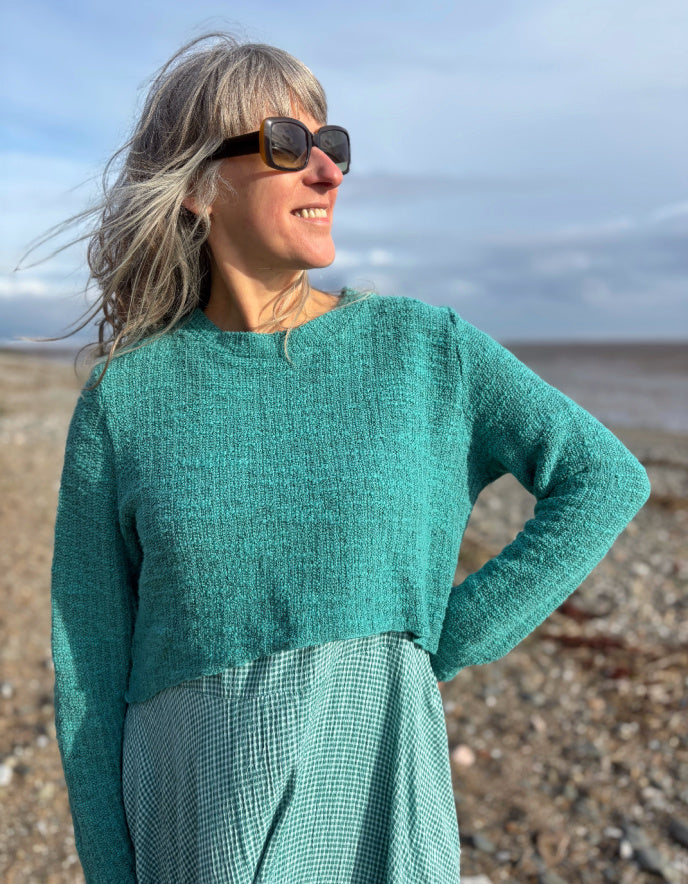 woman wearing cropped jumper over maxi bubble dress in teal