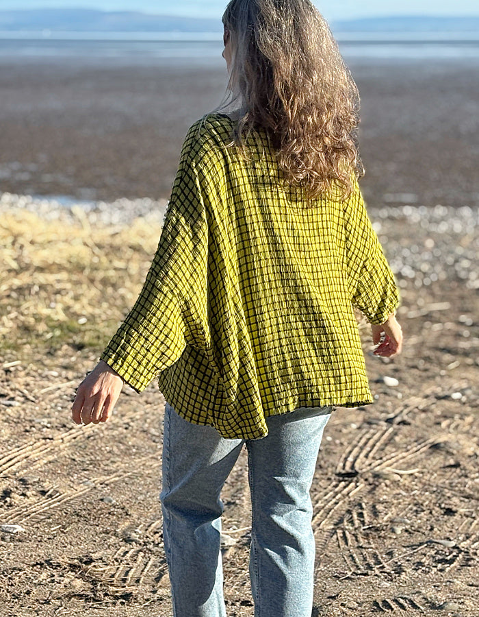 oversized one size top with drape. ochre shade of green with black check print, round neckline