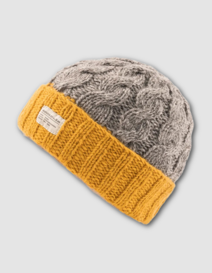 Gray knit beanie with mustard yellow band on a light gray background