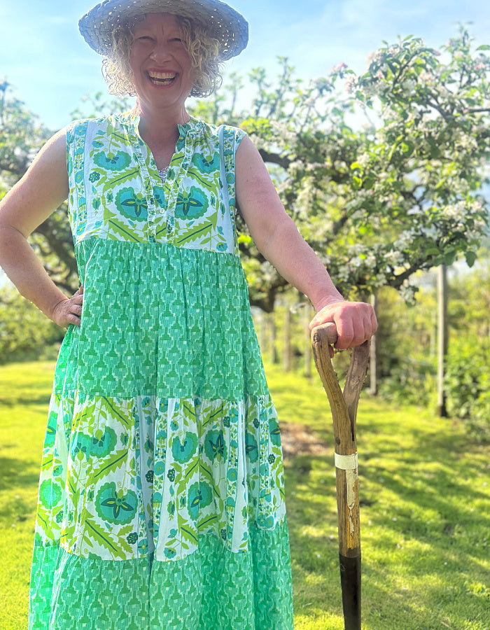 maxi length tiered sleeveless dress with a 70's retro vibe with a green and lime graphic floral print