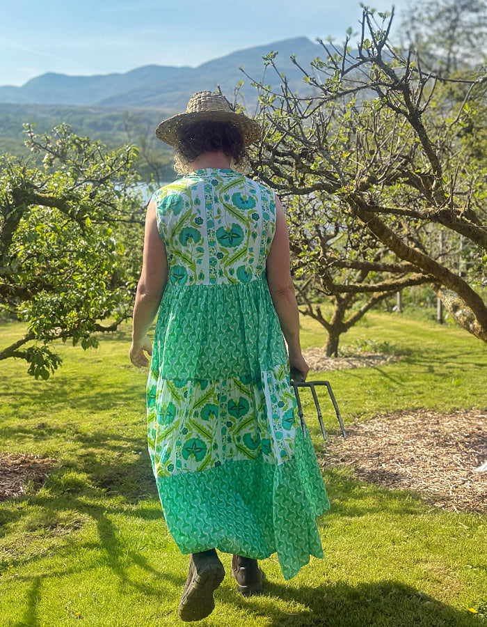 maxi length tiered sleeveless dress with a 70's retro vibe with a green and lime graphic floral print