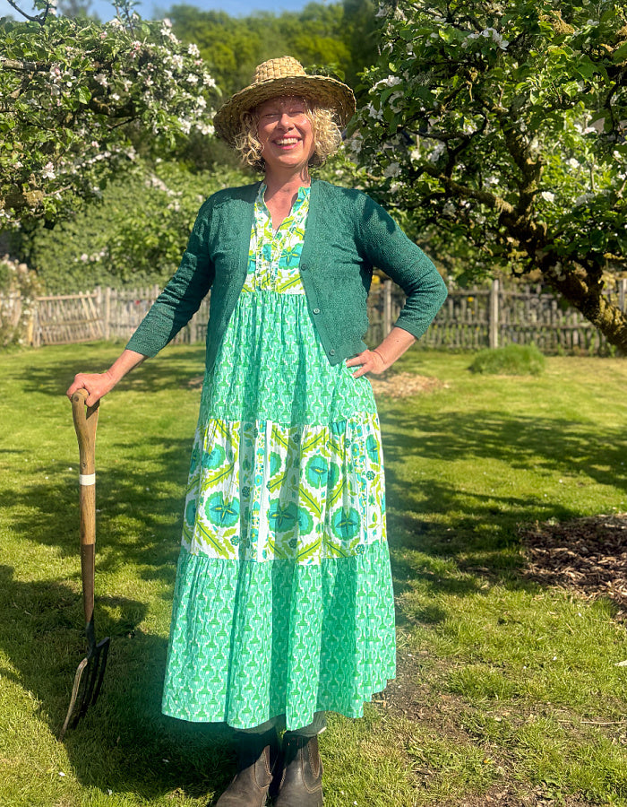 maxi length tiered sleeveless dress with a 70's retro vibe with a green and lime graphic floral print