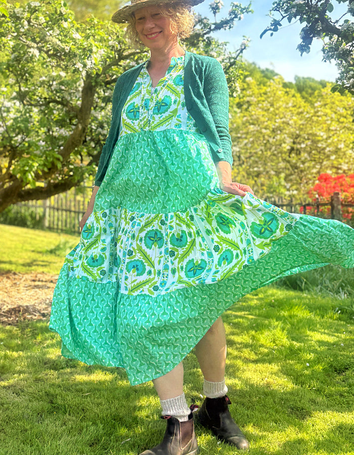 maxi length tiered sleeveless dress with a 70's retro vibe with a green and lime graphic floral print