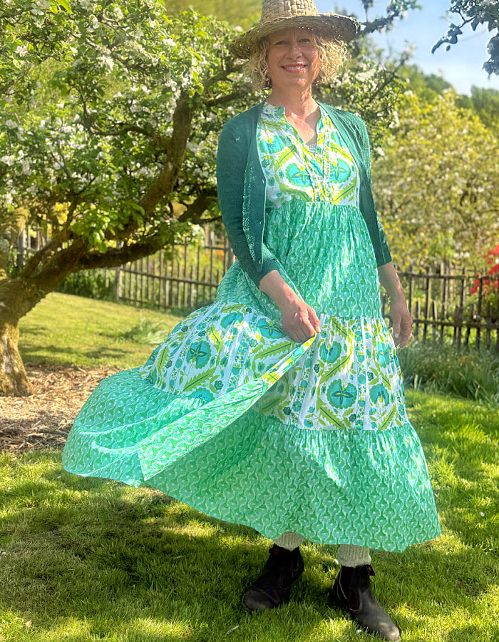 maxi length tiered sleeveless dress with a 70's retro vibe with a green and lime graphic floral print