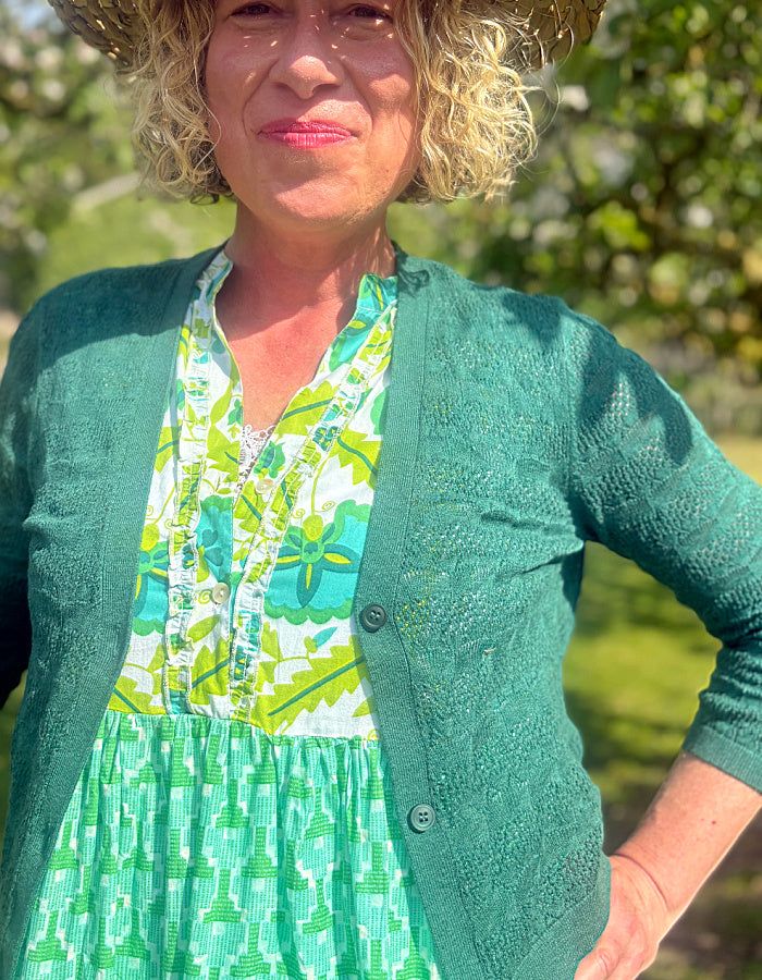 maxi length tiered sleeveless dress with a 70's retro vibe with a green and lime graphic floral print