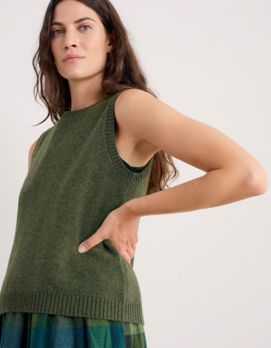 Woman wearing a green sleeveless merino sweater in olive green 