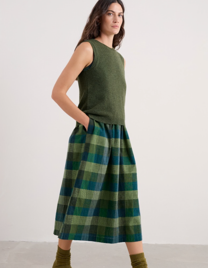 Woman wearing a green sleeveless merino sweater in olive green 