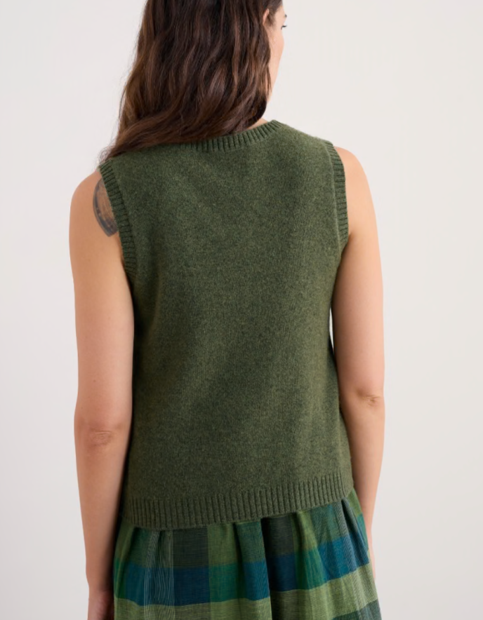 Woman wearing a green sleeveless merino sweater in olive green 