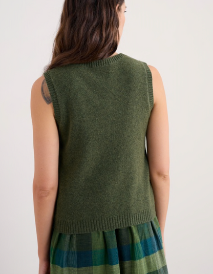 Woman wearing a green sleeveless merino sweater in olive green 