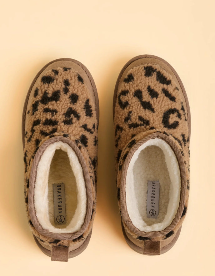 Pair of leopard print slippers on a beige background
