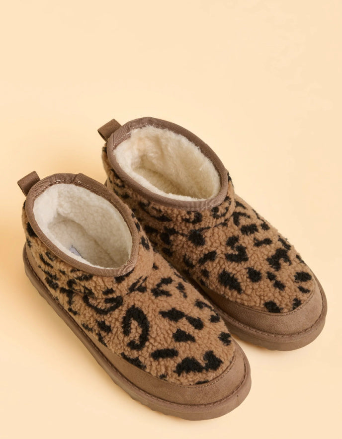 Pair of leopard print slippers on a beige background