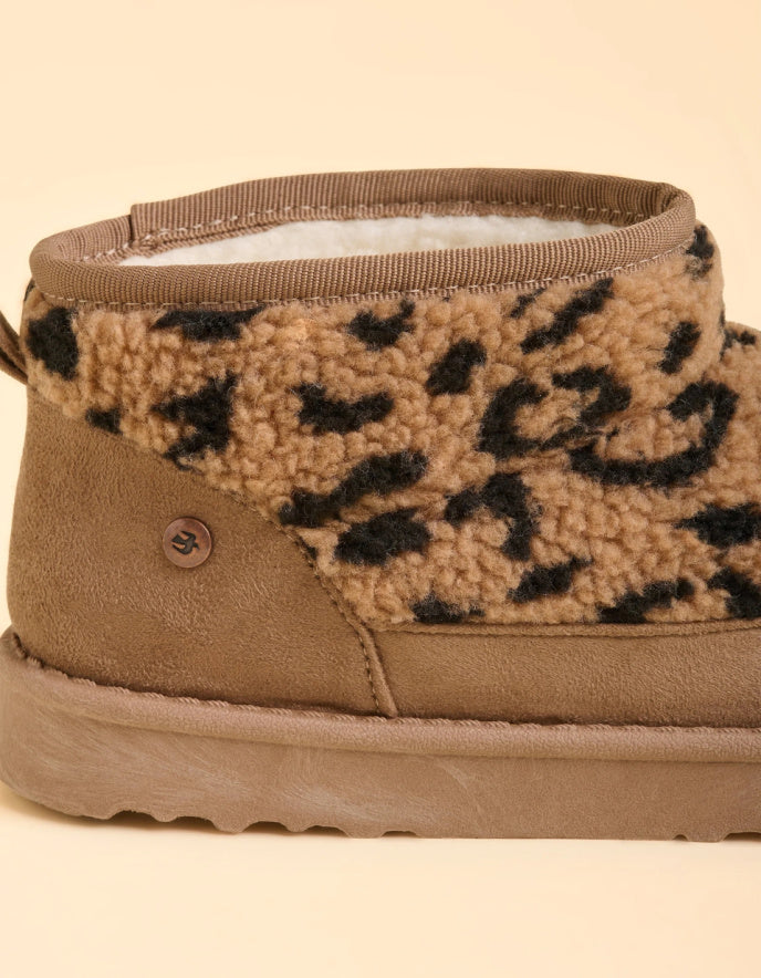 Tan boot with leopard print lining on a beige background