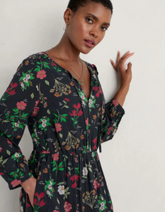 cotton floral Christmas midi length dress with v neckline and pockets and blouson sleeves, featuring a black and festive red floral print
