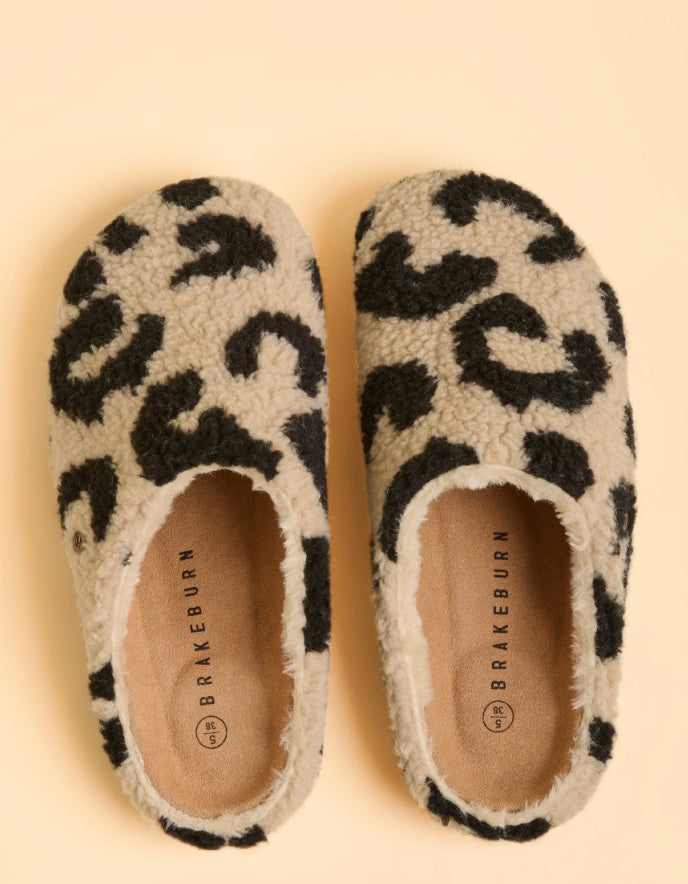 Pair of leopard print slippers with 'Brakeburn' branding on a beige background