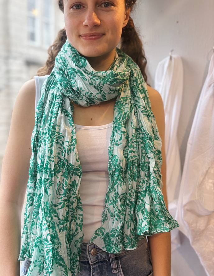 Woman wearing a green and white patterned scarf