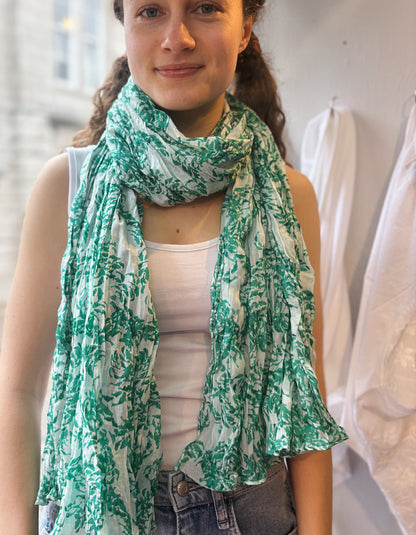 Woman wearing a green and white patterned scarf