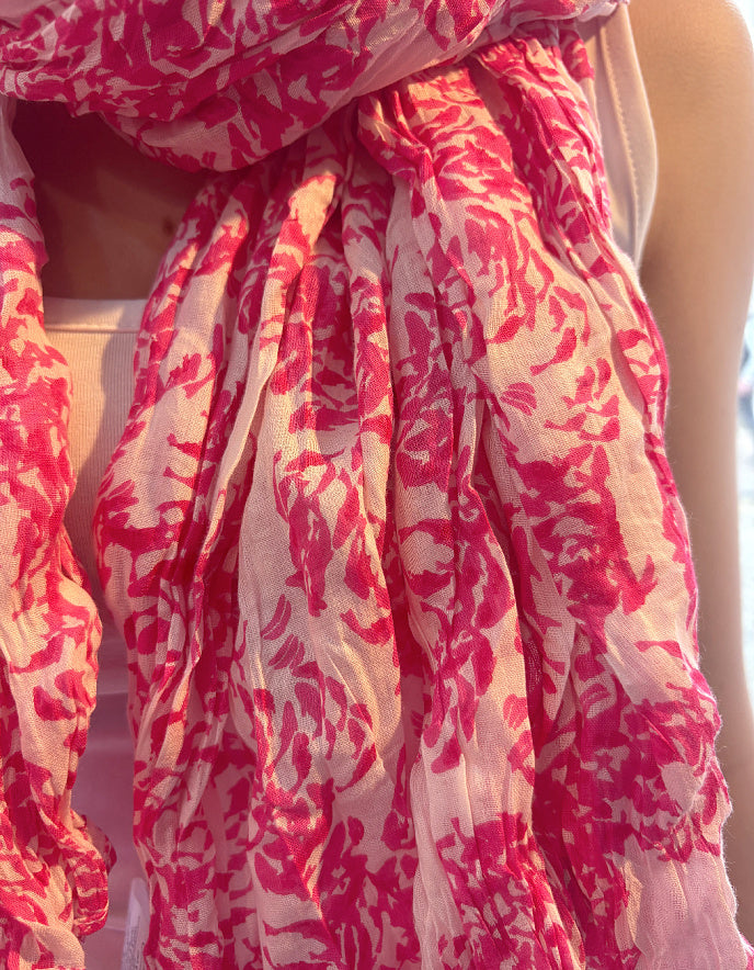 Red and white floral patterned scarf draped around a person's neck.