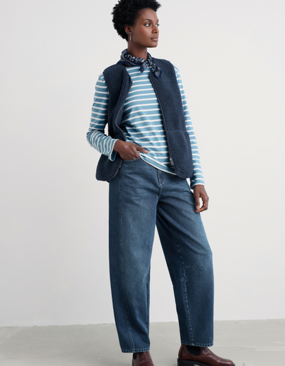 Person wearing a striped shirt, vest, and jeans on a white background