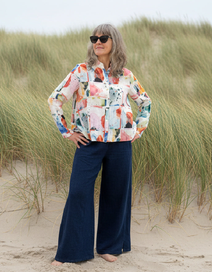 Woman wearing a colorful shirt and sunglasses on a beach