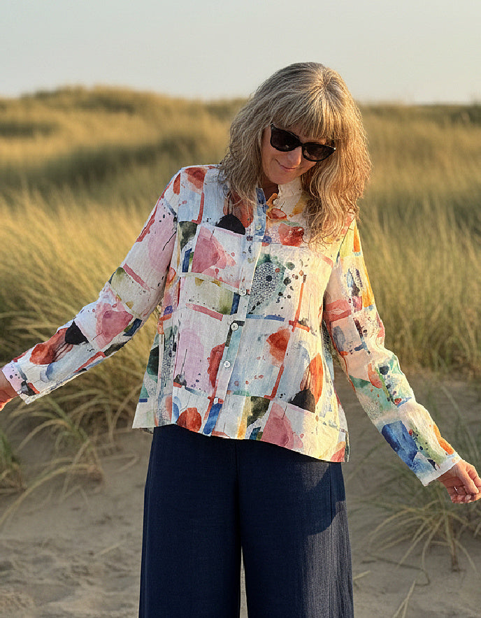 Woman wearing a colorful shirt and sunglasses on a beach