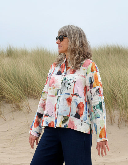 Woman wearing a colorful shirt and sunglasses on a beach