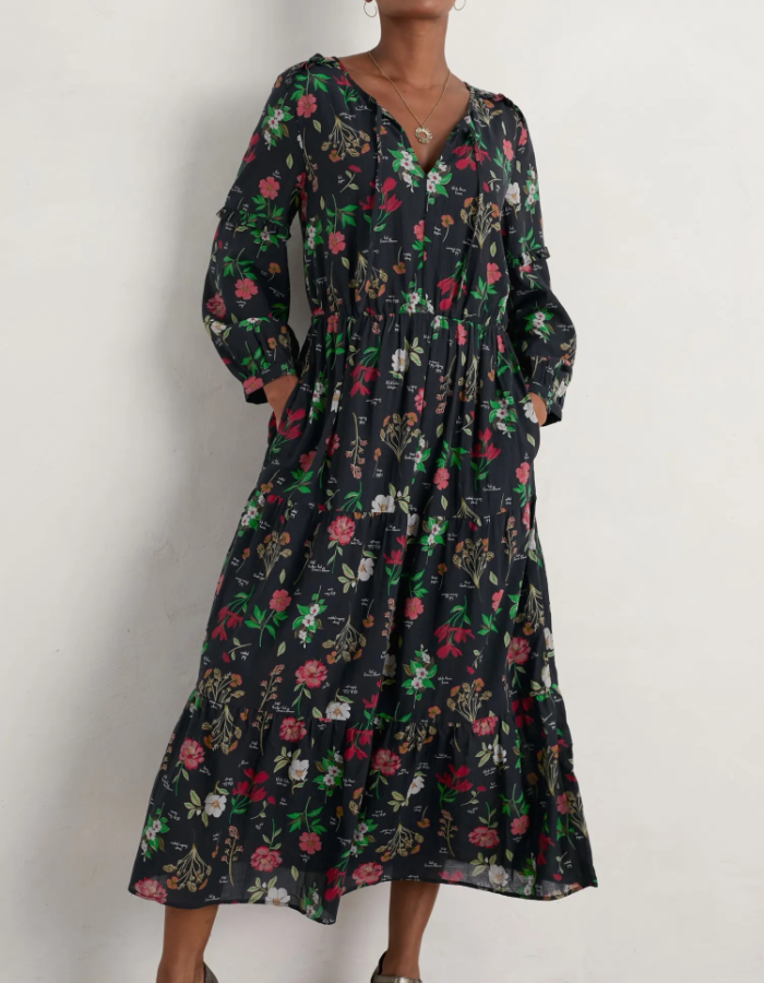 cotton floral Christmas midi length dress with v neckline and pockets and blouson sleeves, featuring a black and festive red floral print