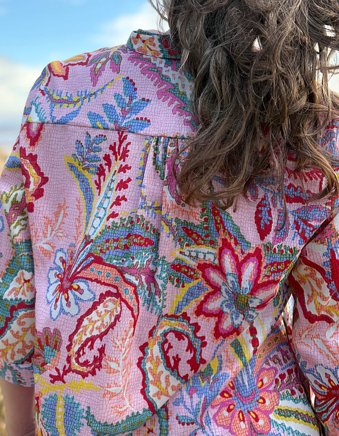 woman wearing a rose print cotton shirt dress over cream jeans