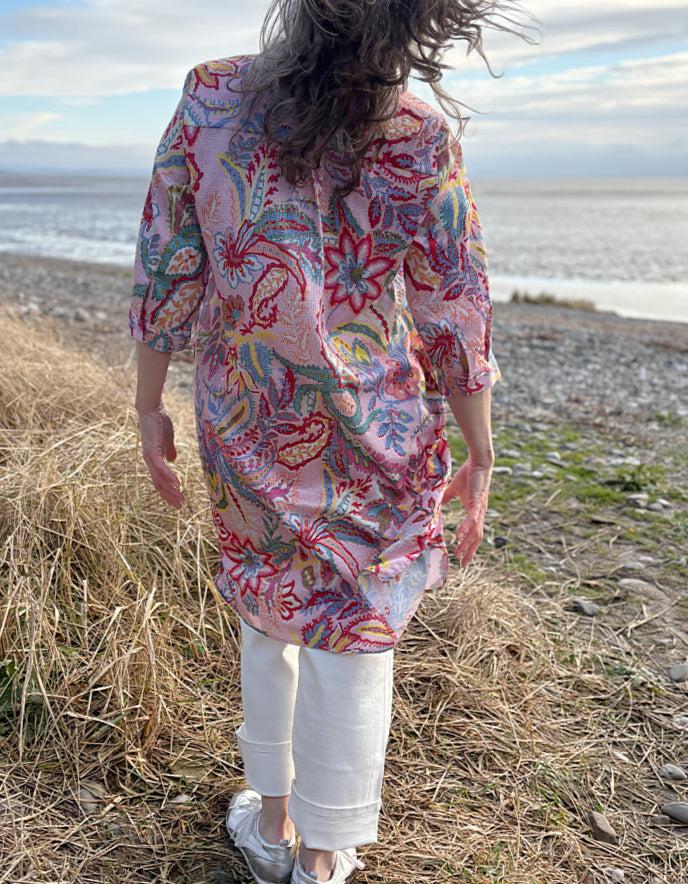 woman wearing a rose print cotton shirt dress over cream jeans